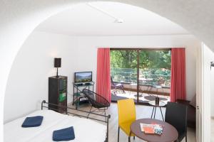 1 dormitorio con cama, mesa y balcón en Aparthotel Al Lago en Locarno