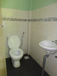 a bathroom with a toilet and a sink at Pristine Hotel in Rawang