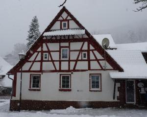 a house is covered in snow at Ferienhaus Katharina in Nothweiler