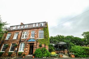 an old brick building with ivy on it at Bowburn Hall Hotel in Durham