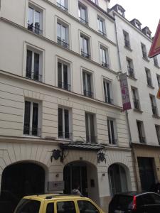 un coche amarillo estacionado frente a un edificio en Hôtel Soft, en París