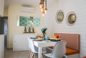 a dining room with a white table and chairs at Batata - Ocean View in Nazaré +25 photos