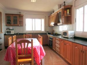 een keuken met een tafel met een rode en witte tafeldoek bij La Casa de la Lluna in El Poblenou del Delta