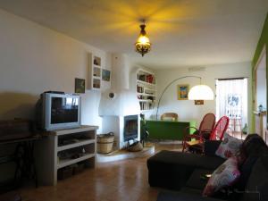 salon z telewizorem i kominkiem w obiekcie La Casa de la Lluna w mieście El Poblenou del Delta
