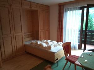 a bedroom with a bed and a chair and a window at Panoramawohnung Bad Hofgastein in Bad Hofgastein