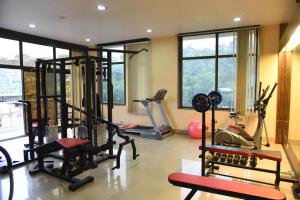 a gym with several exercise equipment in a room with windows at Hotel Pybss in Itānagar