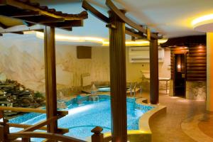 a large swimming pool in a room with at Villa Rossa Hotel in Chişinău