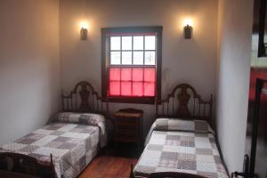 two beds in a room with a window at La Casa del Abuelo in Los Sauces