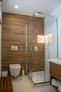 a bathroom with a shower with a toilet and a sink at Batata - Ocean View in Nazaré