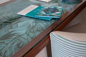 a glass table with two books and a chair at Atlantic Hôtel & Spa in Les Sables-d'Olonne