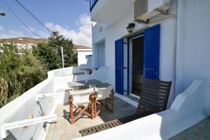 a small balcony with a table and a chair at Standing Stone in Kionia