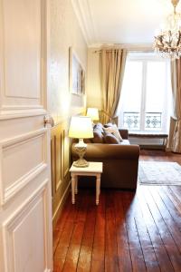 パリにあるLe Triomphe Elyseesのリビングルーム(ソファ、ランプ付きテーブル付)