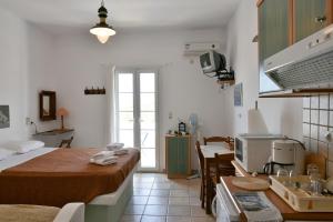 een kamer met 2 bedden en een keuken met een tafel bij Standing Stone in Kionia