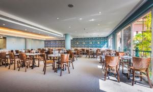 una sala da pranzo con tavoli e sedie e grandi finestre di Pestana Royal All Inclusive Ocean & Spa Resort a Funchal