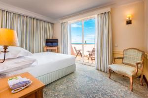 una camera d'albergo con un letto e un balcone di Pestana Royal All Inclusive Ocean & Spa Resort a Funchal Altre 51 foto