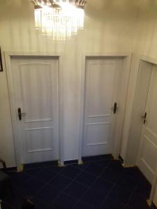 two white doors in a room with a chandelier at Hotel Bad Langensalza Eichenhof in Bad Langensalza