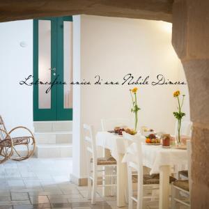 uma sala de jantar com uma mesa branca e cadeiras brancas em B&B Donnantonietta - Nobile dimora em Minervino di Lecce