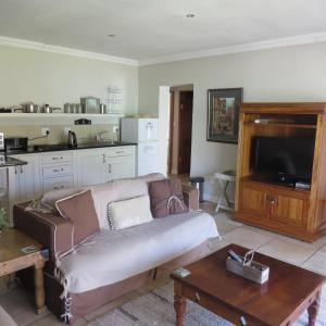 a living room with a couch and a tv at Bella Vista Self Catering in Clarens