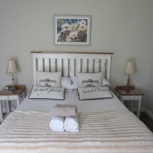a bed with two towels and two pillows on it at Bella Vista Self Catering in Clarens