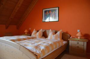 a bedroom with a bed with an orange wall at Schuler-Petschler in Obereisenheim