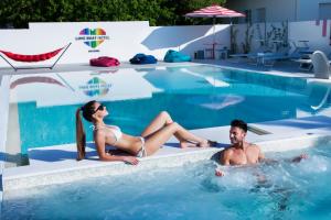 un homme et une femme assis dans une piscine dans l'établissement Love Boat Hotel - The Original, à Riccione