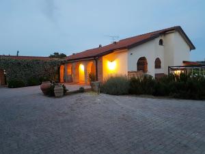 a house with a brick driveway in front of a building at La Valle dei Peschi in Vada