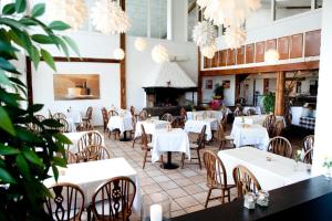 グラセンにあるBenniksgaard Bed & Breakfastの白いテーブルと椅子、暖炉のあるレストラン