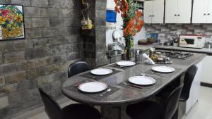 a table in a kitchen with chairs and plates on it at Grace Home in New Delhi