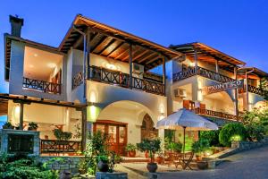 a house with an umbrella in front of it at Archontiko in Ammouliani