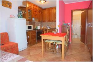 uma cozinha com uma mesa com uma toalha de mesa vermelha em Apartments Nives NB em Savudrija