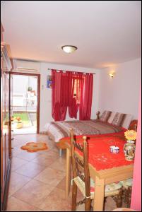 sypialnia z łóżkiem i stołem z czerwoną zasłoną w obiekcie Apartments Nives NB w mieście Savudrija