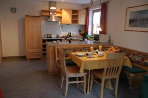 a kitchen with a table and chairs and a kitchen with a counter at Ferienwohnungen Franz Pfeifer / Beatrice Roduner in Gaschurn