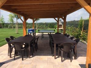 a patio with tables and chairs under a wooden pavilion at Agriturismo Pigno in Villafranca di Verona