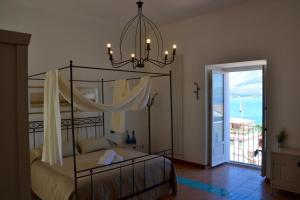a bedroom with a canopy bed with a view of the ocean at Il Bottone al Duomo in Gaeta