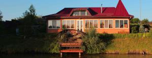 a house with a red roof sitting on the water at Fisherman's House in Rasavka