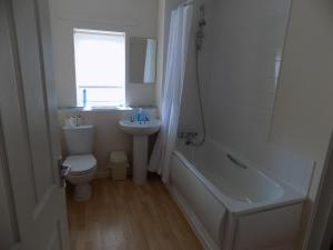 Baño blanco con aseo y lavamanos en A Home From Home 2 en Plymouth