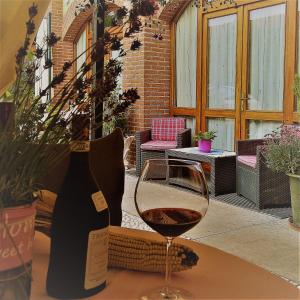 un bicchiere di vino accanto a una bottiglia di vino di Macallè a Momo