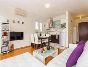 a living room with a white couch and a table at La Vita e Bella Apartment in Hvar