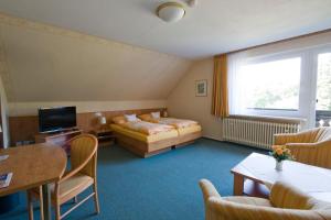 a hotel room with a bed and a television at Mein Vierjahreszeiten Hotel Garni Superior in Sankt Andreasberg