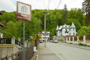 a street sign in a town with a house at IL Piccolo Castello Busteni in Buşteni