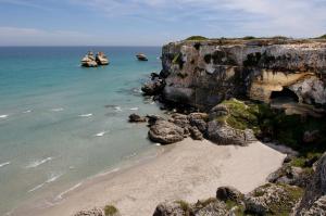 a view of a beach with rocks and the ocean at Casa vacanza Poesia in San Foca