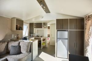 ラ・パルミールにあるMobile Home Luxe - La Palmyreのリビングルーム、キッチン(ソファ、冷蔵庫付)