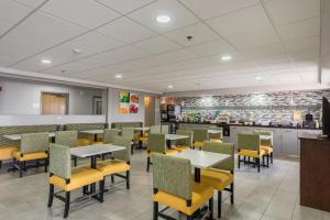 a dining room with tables and yellow chairs at Quality Inn Grove City - Columbus South in Grove City