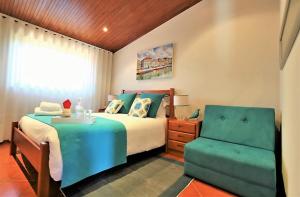 Casa da Ribeira في أفيرو: غرفة نوم بسرير وكرسي أخضر