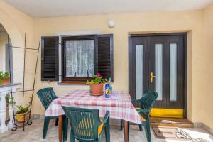 a table and chairs with a table and a window at Apartments Nevenka in Krk