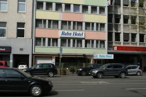 un estacionamiento con autos estacionados frente a un edificio en Bahn-Hotel, en Düsseldorf