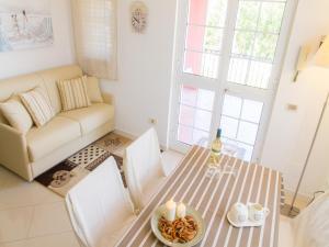 a living room with a table and a couch at Gelso Bianco Apartments in Campofelice di Roccella
