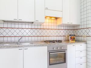 a kitchen with white cabinets and a stove top oven at Gelso Bianco Apartments in Campofelice di Roccella +45 photos