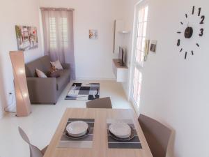 a living room with a table and a couch at Gelso Bianco Apartments in Campofelice di Roccella