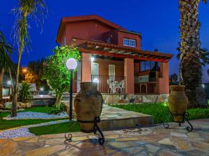 a house with two large vases in front of it at Gelso Bianco Apartments in Campofelice di Roccella